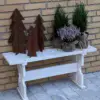 Smukke træer/juletræer i cortenstål på en bænk med blomster