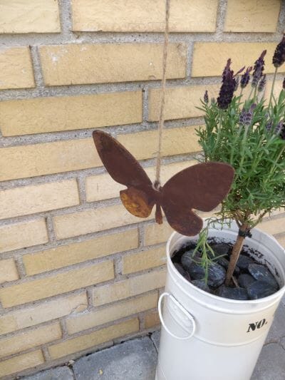 Sommerfugl med blød kant på snor 1 Sommerfugl i cortenstål som hænger over en blomsterkrukke